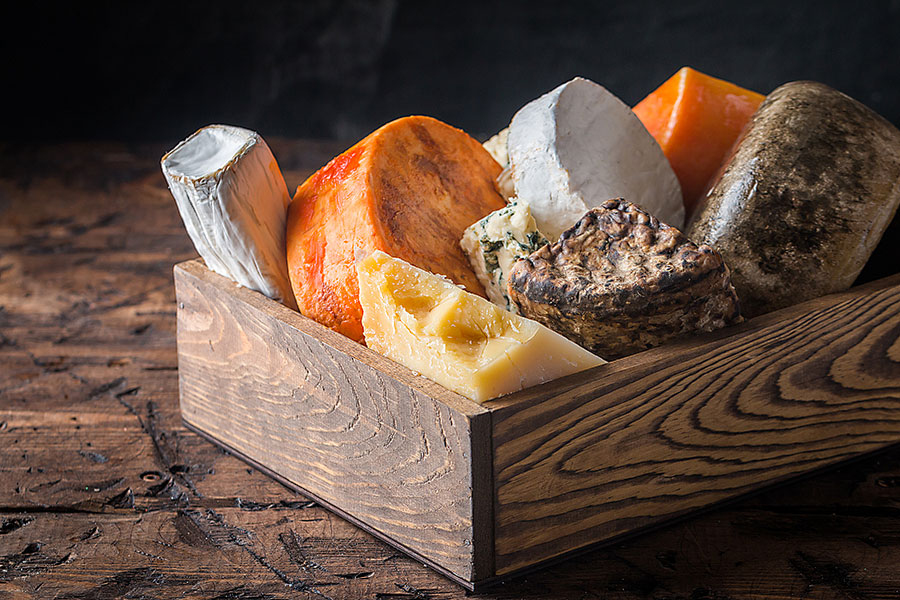 different types of cheese in a wood box