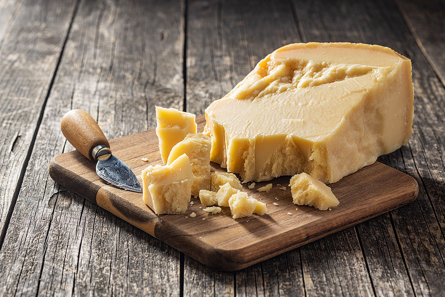 parmigiano reggiano or parmesan cheese on a cutting board