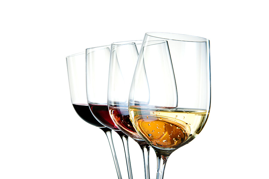Four wine glasses with different colors of wine